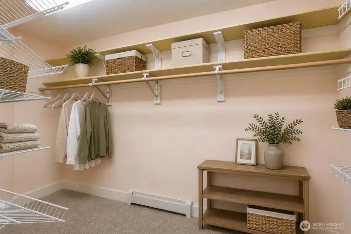 Virtually staged. Spacious walk-in closet featuring extensive shelving, hanging space, and room for organized storage.