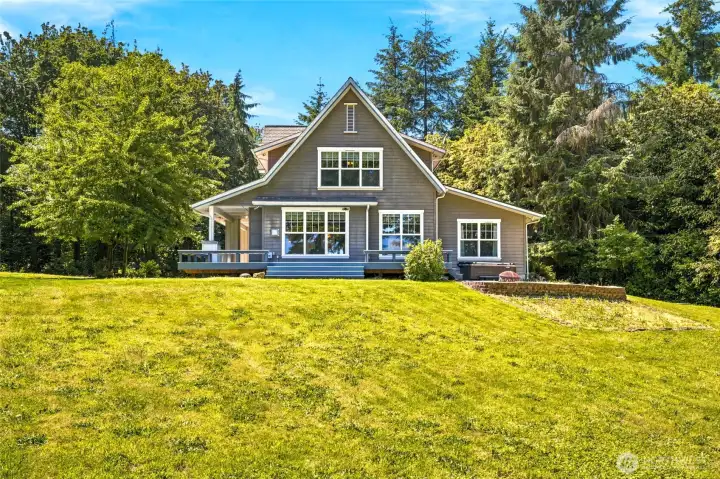 Charming Craftsman exterior set on nearly 3 acres, with expansive lawn space and a private, park-like setting.