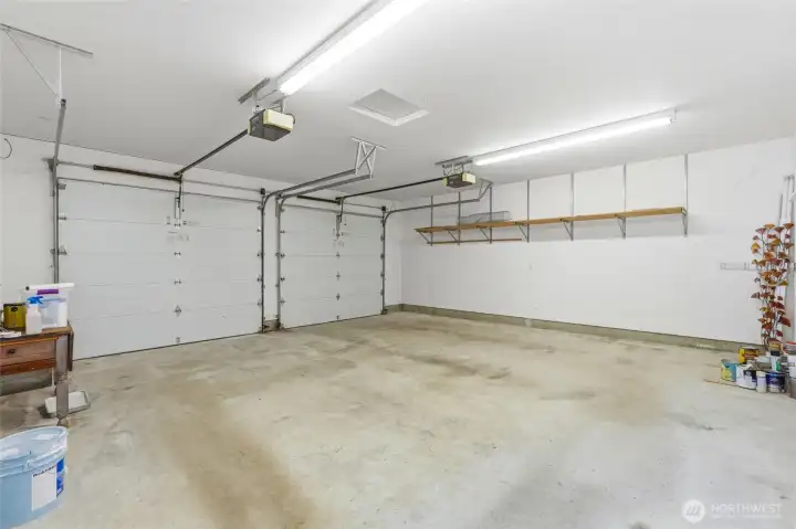 Generous two-car garage with built-in storage, bright overhead lighting, and abundant space for parking and projects.