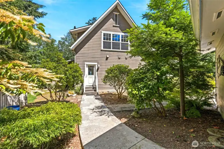 A paved walkway between the detached garage and home leads directly to the side entrance, offering convenient access to the spacious laundry and pantry area.
