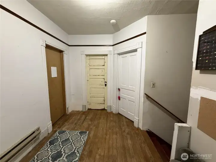 View at the top of the landing on the 2nd floor to 3 of the bedrooms - the door to the left with the white board on the door is the largest of the bedrooms. There are no photos of the interior of the room behind the ivory door. Behind the white door is the bedroom painted pink.