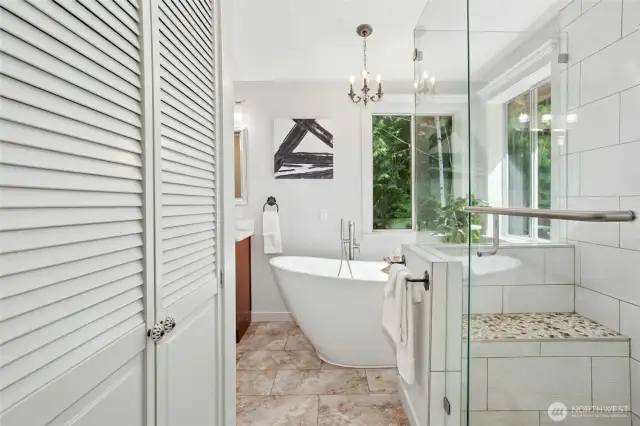 Updated primary bath features a large soaking tub, double vanities, a luxurious shower, and private toilet.