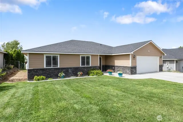 Exterior of home features concrete siding & stone accents