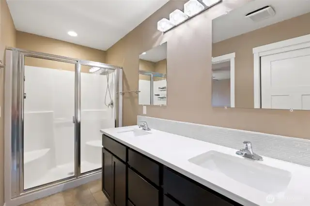 Primary Bathroom features dual vanity, walk-in shower w/glass door