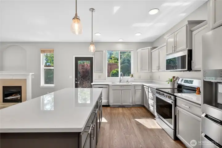 Bright kitchen with large island and sink window overlooking private backyard