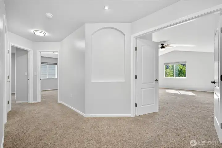 Upstairs hallway showcasing layout of secondary bedrooms, bathroom, and primary suite