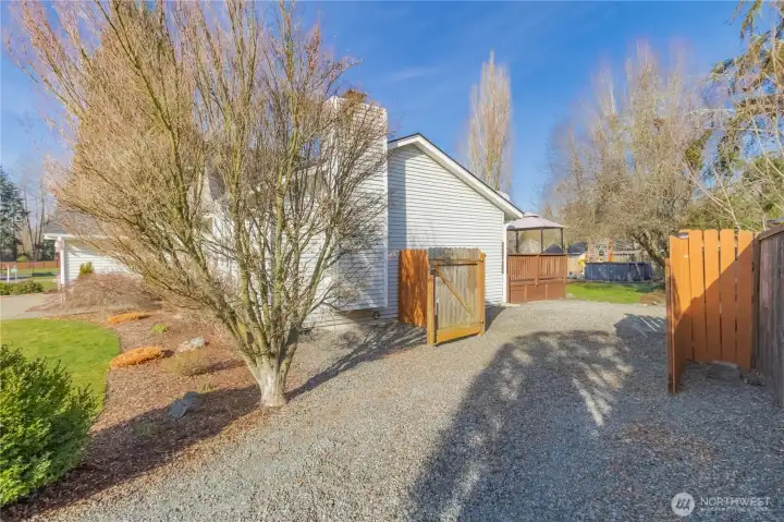 Gravel access with double gate to back yard.