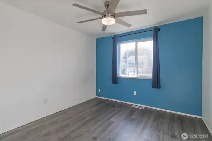 Bedroom 1 with new laminate flooring and lighting.