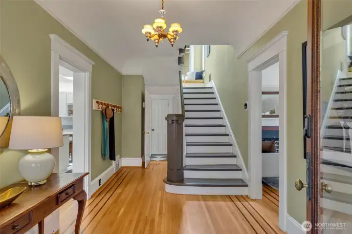 The elegant foyer leads to a light-filled central staircase with window seat.