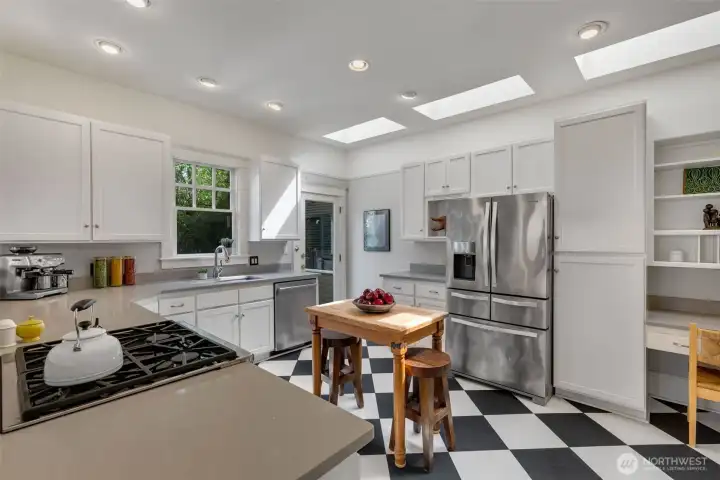 Tasteful quartz counters and abundant cabinets provide ample storage and work area.