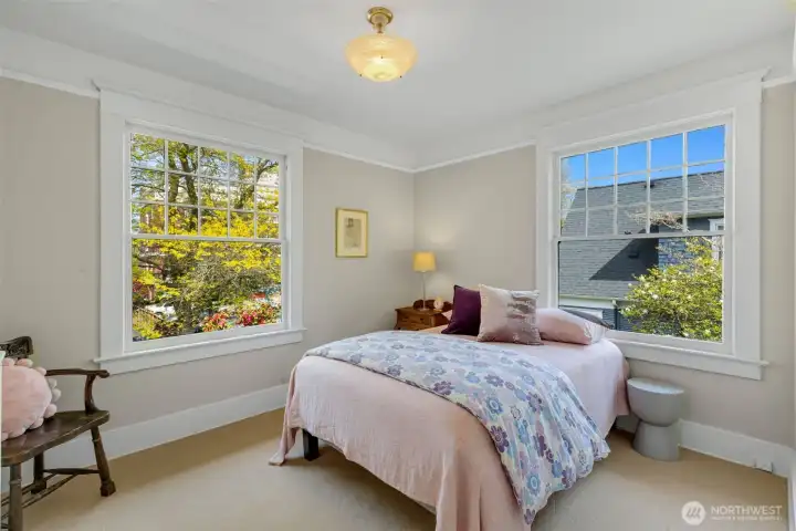 Corner windows flood this bedroom with light.