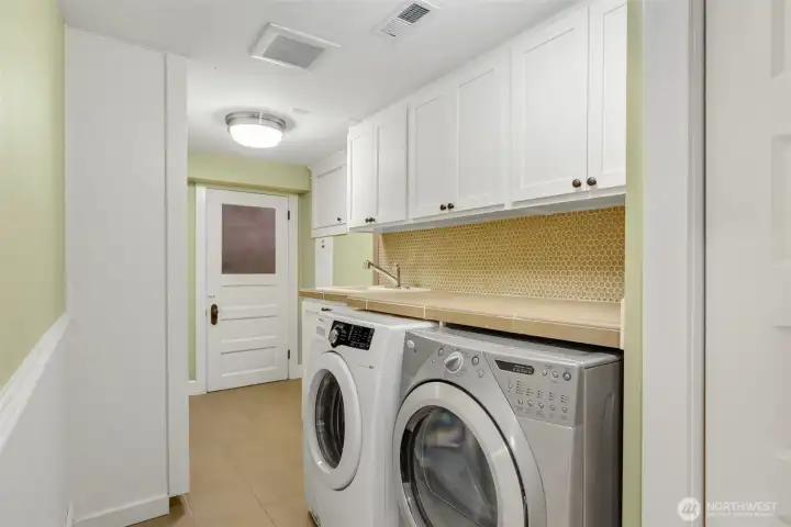 Large laundry with stone countertop.
