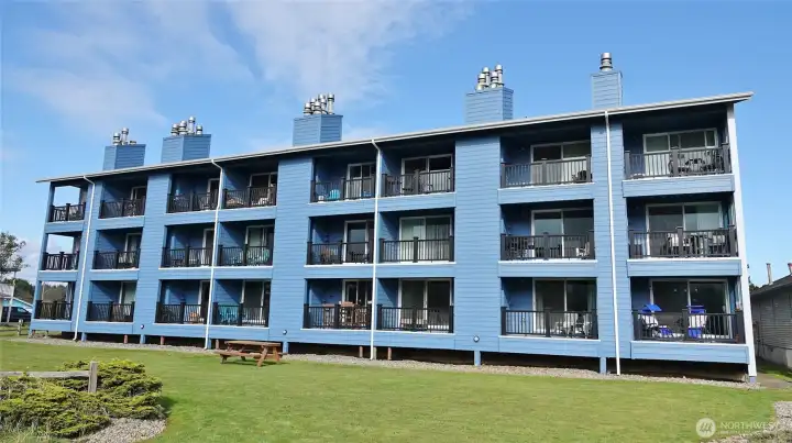 Rear view of the Nautilus building.  Remodel completed in 2025. #202 is the 2nd floor, 2nd unit from the right.