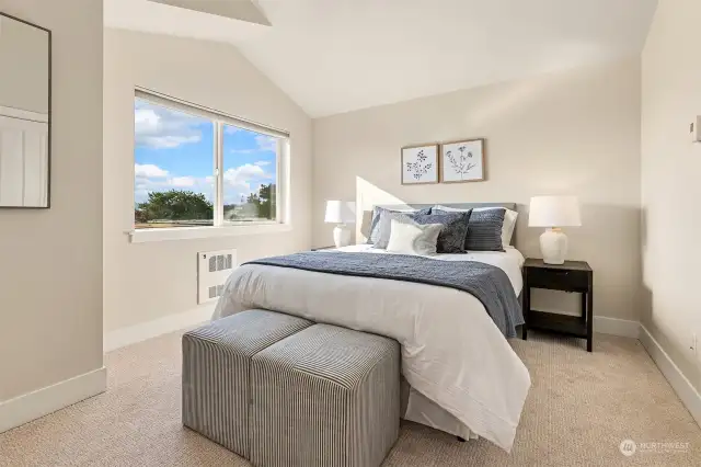 Primary bedroom features a vaulted ceiling, generous closet, views of Mt. Rainier and partial City views, and a handy bath sink area to help with double duty.