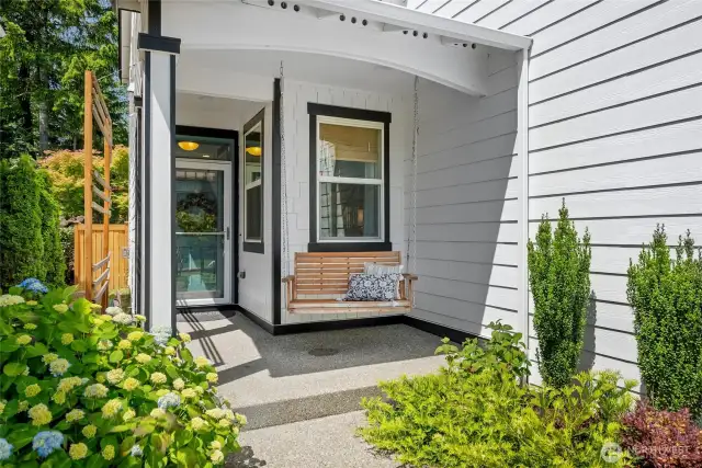 This dreamy front porch features a charming hanging swing and a convenient spot for all your Amazon deliveries.