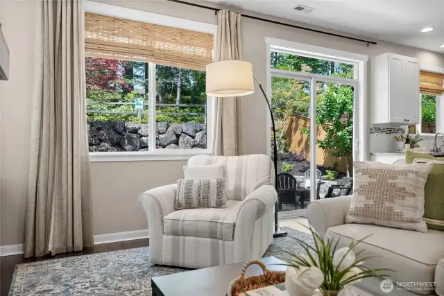 Huge picture windows and a sliding glass door look out to a private backyard setting.