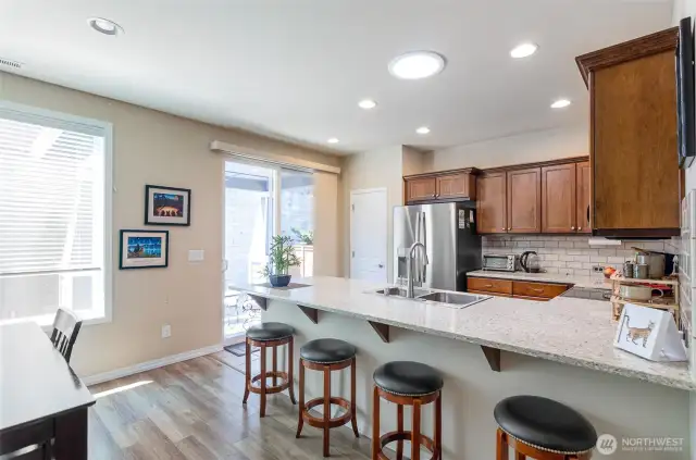 Open kitchen offers rich cabinetry, and updated countertops, backsplash and new appliances.