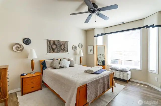 Primary bedroom is located in the back of the home.  Bay window offers natural light.  Wood wrapped windows, all complete with window treatments.