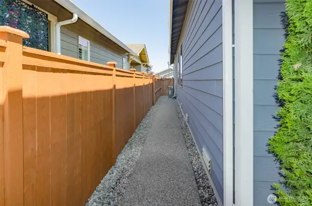 Paved walk ways on both sides of this home.  Notice the brand new quiet AC unit.