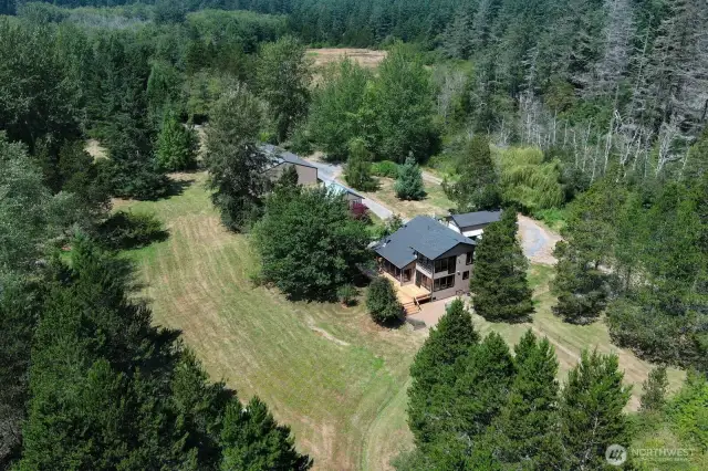 Aerial view of property shows main house. Several out buildings for exercise as well as a detached 2520 sq foot detached shop, a single car garage.