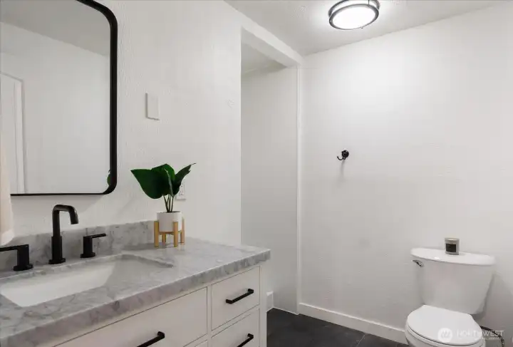 Main bath includes new vanity with marble top and new vinyl tile flooring