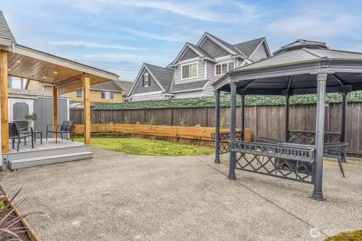 Spacious backyard with gazebo, covered patio and garden beds