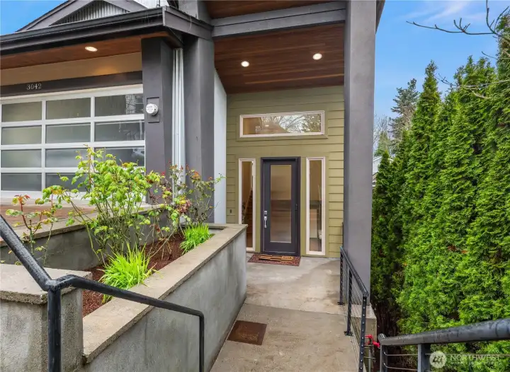 Just off the paver driveway is this formal covered entry with lovely landscaping adding a softness to the hardscape.