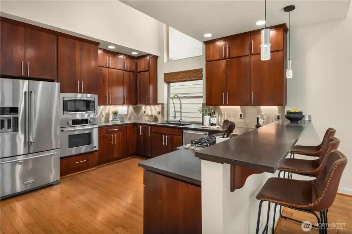This stunning kitchen features tall overhead cabinets and a dramatic vaulted ceiling.