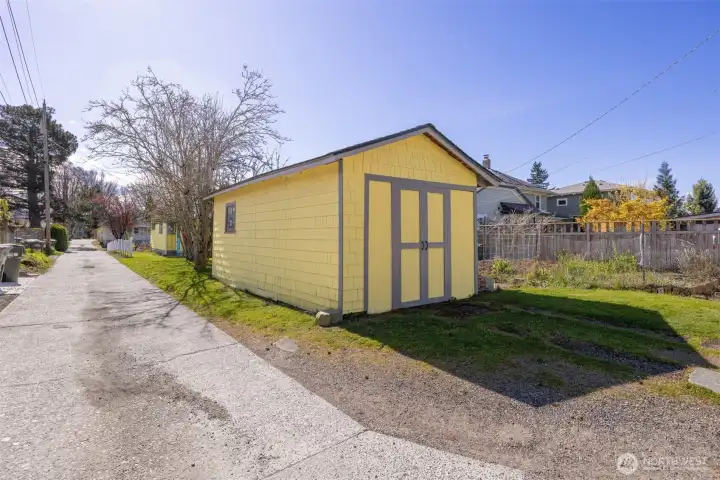 The garage has doors that open and is used as a storage area. There is a large garden space to the west of the garage.