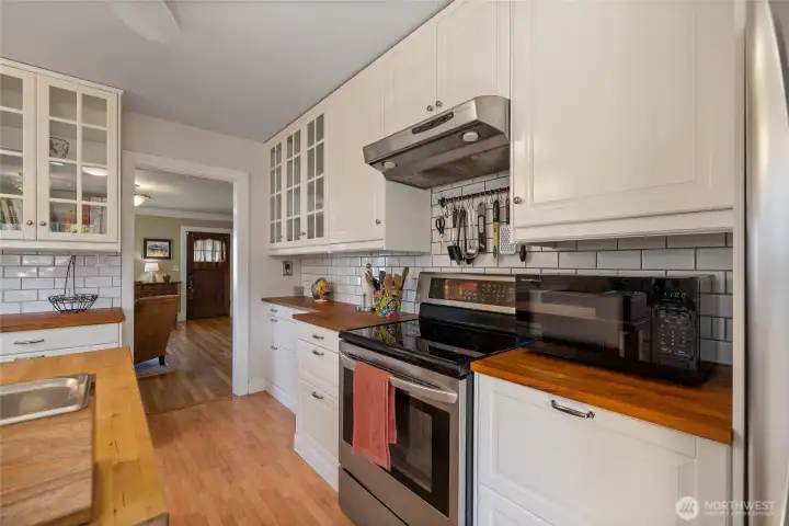 Butcher block counters and stainless steel appliances in the kitchen.