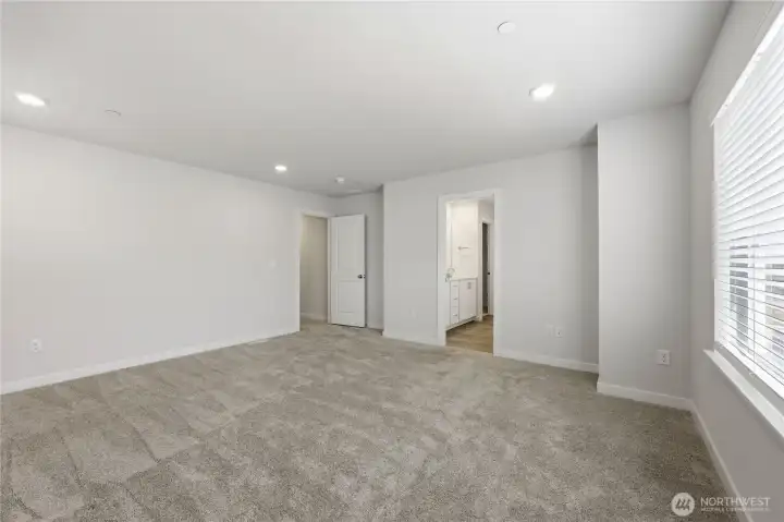 The primary bedroom unstaged leading into the private bathroom. The primary bedroom unstaged leading into the private bathroom.
