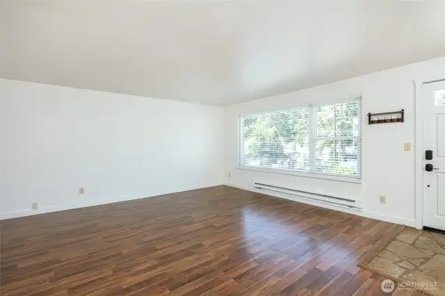 Walking into main living dining area with large windows.
