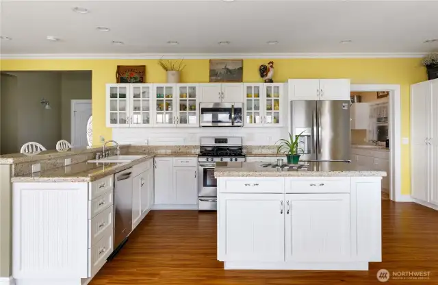Nice granite countertops with these beautiful custom cabinets.  Corner has lazy susan and the island has pull out shelves.  Laundry room is the doorway to the right and then on to the 2 car garage