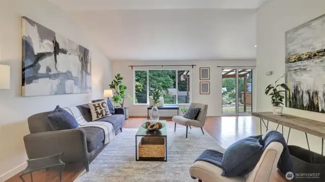Enter to discover beautiful laminate flooring throughout most of the main floor, vaulted ceilings, and walls of windows in this large living room.