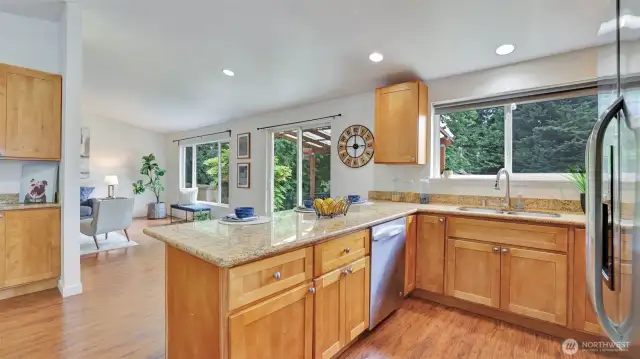 Open sight lines and walls of windows showcasing the lush backyard offer the perfect setting in this kitchen.