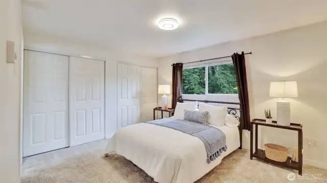 Spacious primary bedroom offers two closets and ample space for furniture or sitting area.