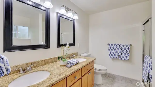 Spacious primary 3/4 bath en suite with double sink vanity and walk-in shower