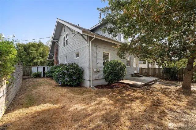 Fully fenced, the side yard has mature landscaping and room for pups to run!
