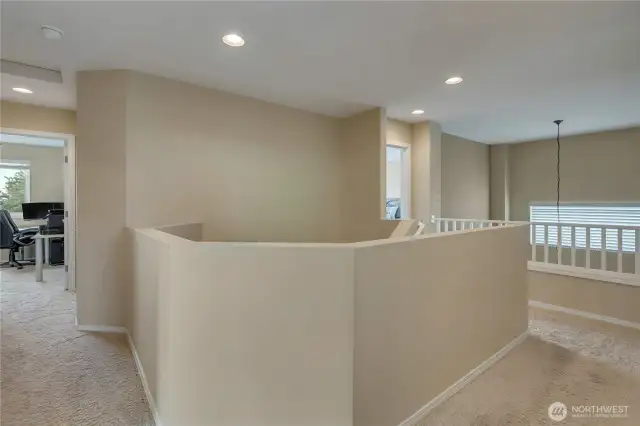 Upstairs hallway with railing open to below dining room.