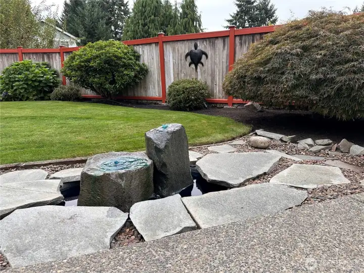Basalt water fountain in the backyard leading to the steps to the cul-de-sac.
