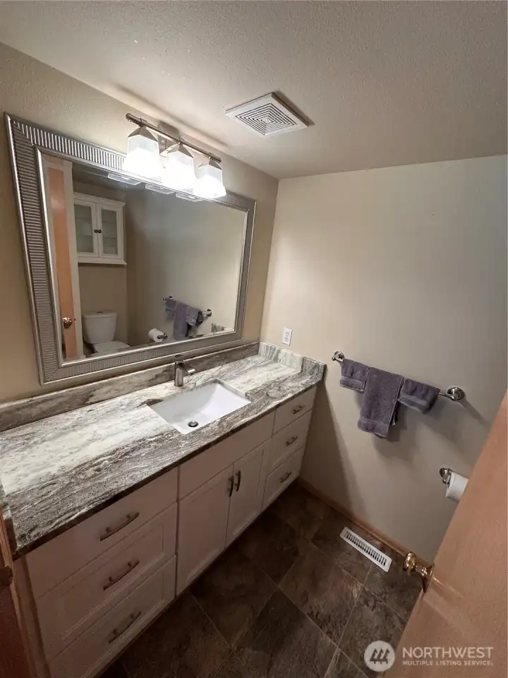 Half bath on the main floor with marble countertops