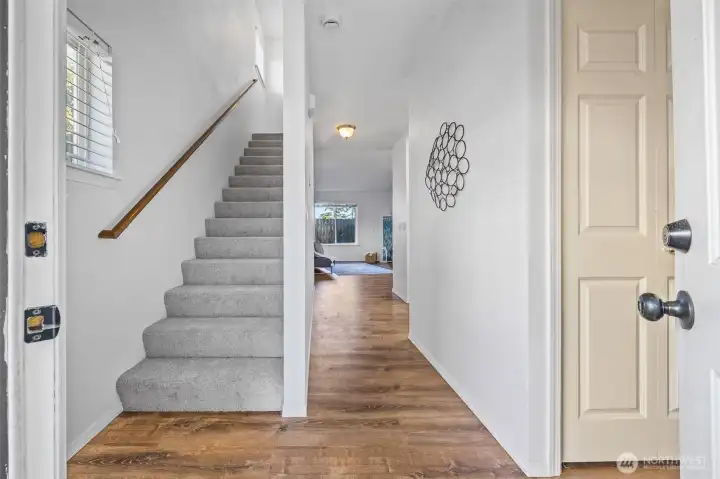 The inviting entry captures the relaxed pace of Whidbey Island living. New carpet (2025) and natural light guide you upstairs to private bedroom retreats.