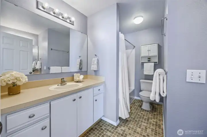 Large ensuite with dual sinks, bright lighting, and modern finishes for everyday comfort.