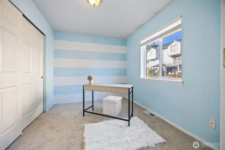 Bright, light-filled third bedroom currently staged as a home office; flexible and functional.