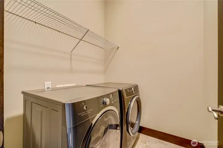 Large utility room features a newer washer and dryer.