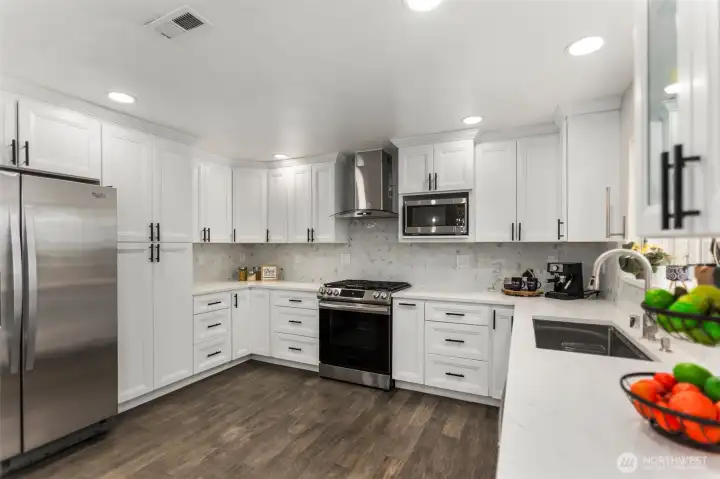 The chef's kitchen is a dream, featuring a generous island, gas cooktop with hood!