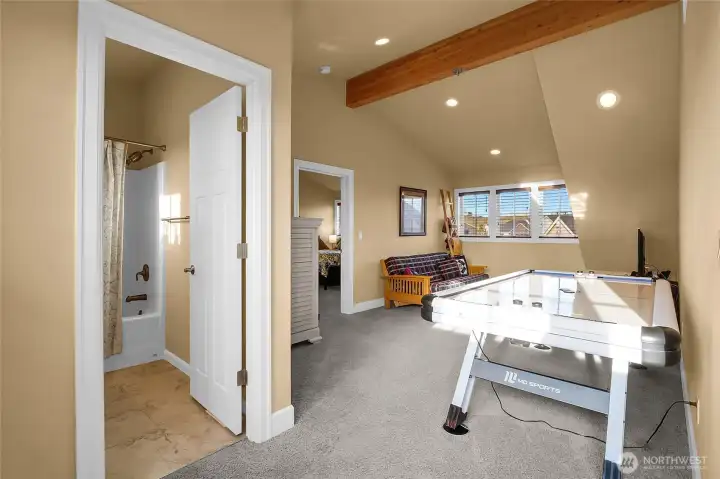 An upper-level living area ready for movie nights, study time, air hocky playing time, or relaxed conversation. Facing the front of the house are the windows and the bedroom we're about to peak into.