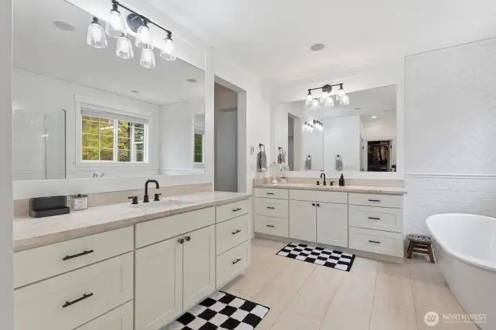The spa-like ensuite primary bath includes heated floors, dual vanities, and a luxe soaking tub.