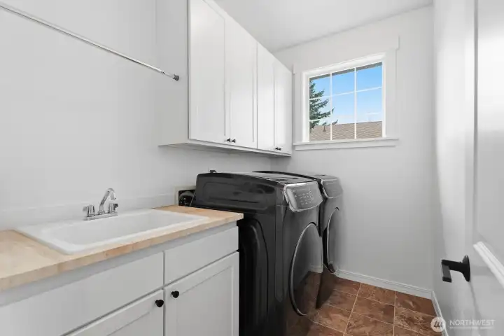 Handy upper level laundry room with a utility sink and storage.