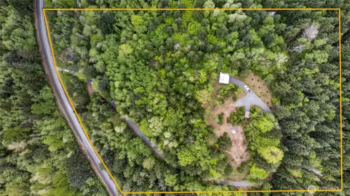 This beautiful acreage has been thoughtfully designed to maximize the stunning views from the cleared building site at the top of the property. Aerial imagery includes an approximate property outline for visual reference only.